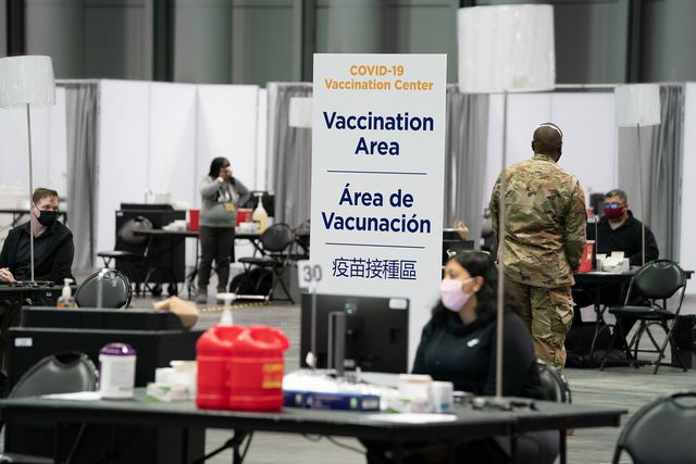A table at the JAvits Center that says 'Vaccination site"